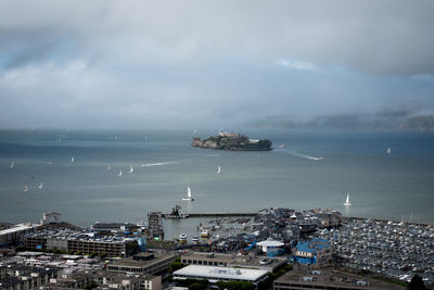 High angle view of sea by buildings against sky