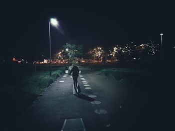 Woman standing on road at night