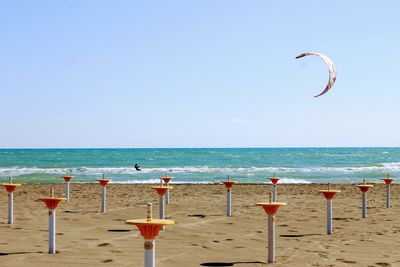 Bollards at beach against clear sky