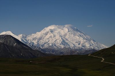 Scenic view of snowcapped mountains against blue sky