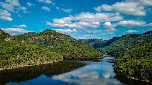 Scenic view of lake and mountains against sky at a dam. 