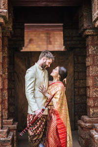 Couple standing against built structure