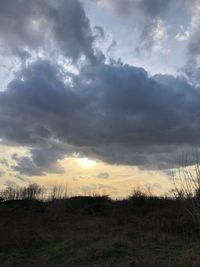 Scenic view of field against dramatic sky
