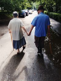 Rear view of senior couple walking on footpath