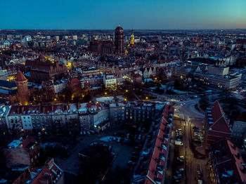 High angle view of illuminated city against sky at dusk