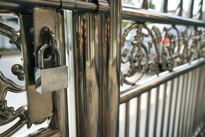 Close-up of padlock hanging from gate