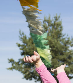 Cropped hands of girl with arms raised against bunting