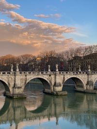 Bridge over river against sky during sunset