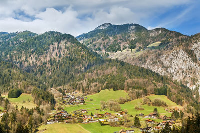 Panoramic view of townscape by mountains against sky