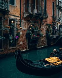 Gondola in canal against buildings 