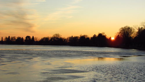 Scenic view of lake against sky during sunset