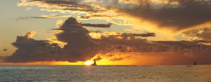 Scenic view of sea against dramatic sky during sunset