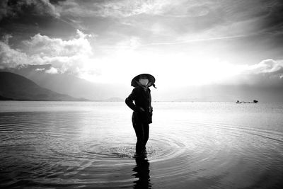 Woman standing on beach at sunset