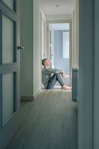 Man with mental disorder sitting on the floor