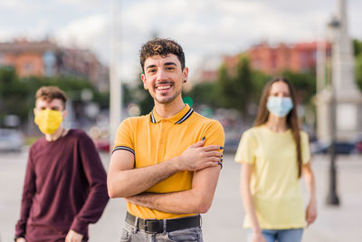 Portrait of smiling young man standing in city