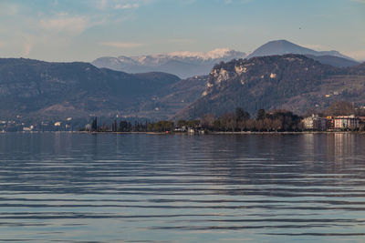 Scenic view of lake by mountains against sky