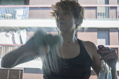 Portrait of woman standing against window