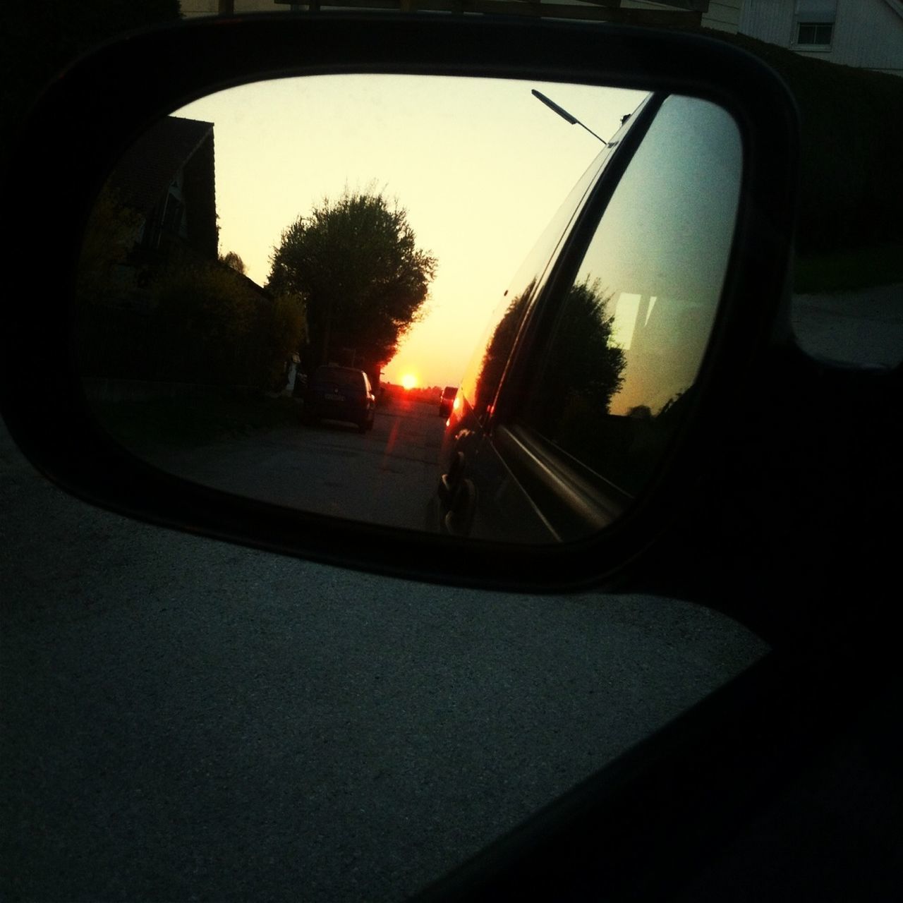 transportation, sunset, car, mode of transport, land vehicle, sun, silhouette, tree, sky, orange color, sunlight, window, glass - material, side-view mirror, sunbeam, road, vehicle interior, reflection, lens flare, transparent