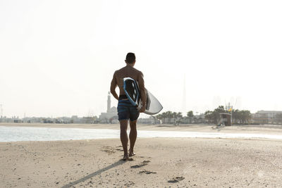 Rear view of man walking on beach