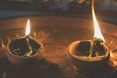 Close-up of burning diyas in plate