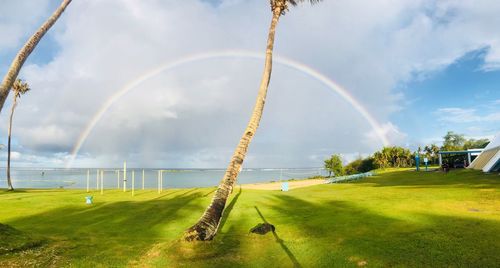 Scenic view of rainbow over land against sky