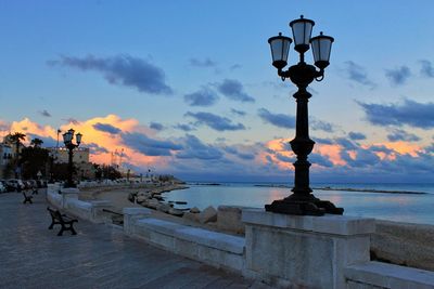 Street light by sea during sunset