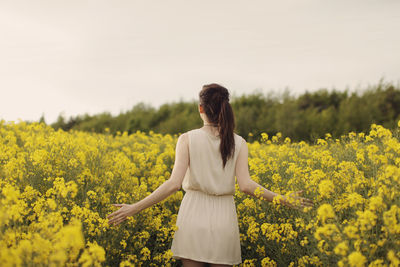 Rear view of woman standing on field