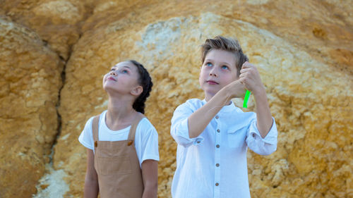 Surprised faces of children watching kite flying sky.