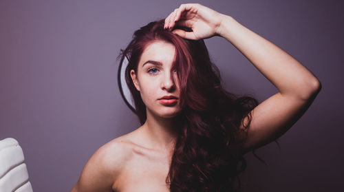 Portrait of sensuous woman wrapped in towel against window