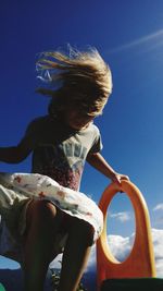 Woman standing against blue sky