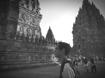 Side view of people outside temple against building