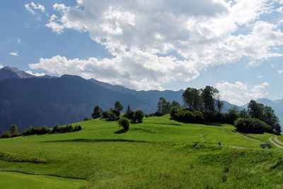 Scenic view of field and mountains against sky