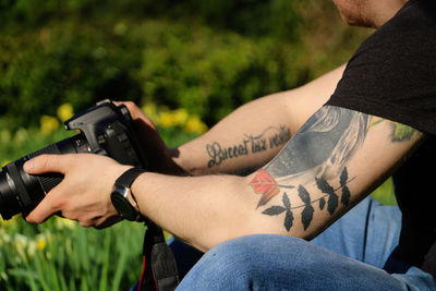 Man with tattoos taking photos