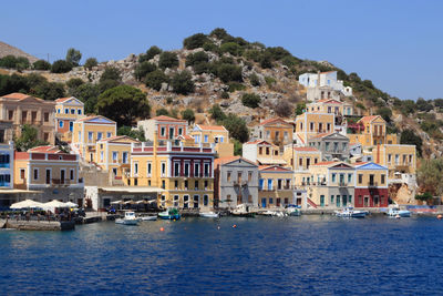 Buildings by lake against sky in city