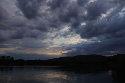 Scenic view of dramatic sky over lake during sunset