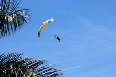 Low angle view of person paragliding against sky