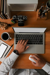 Low section of person using laptop on table