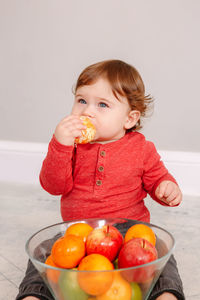 Portrait of cute girl holding fruits