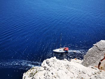 High angle view of people on rock by sea