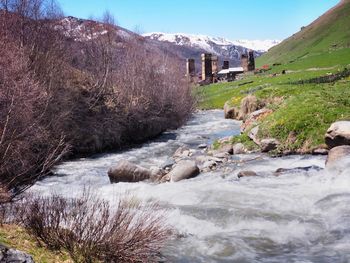 Scenic view of river amidst mountains against sky