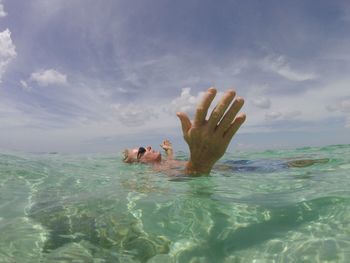 Man swimming in sea against sky