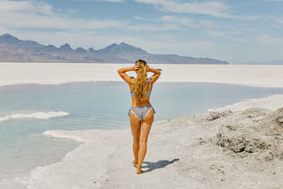 Young woman in bathing suit exploring the bonneville salt flats.