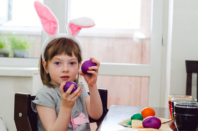 A little girl is painting eggs for the easter holiday.