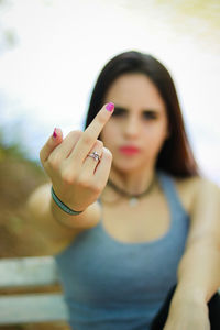 Woman showing middle finger on bench