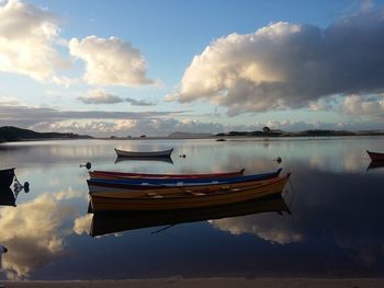 Boat moored in lake against sky