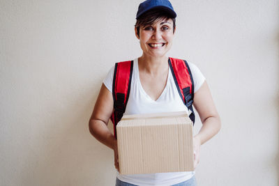 Portrait of smiling delivery person holding parcel
