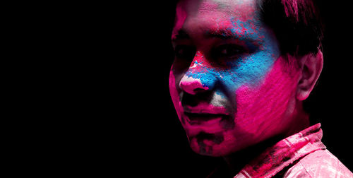 Close-up portrait of a man in black background
