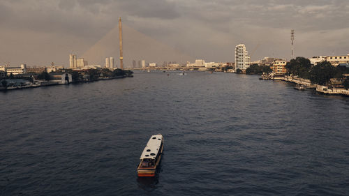 Ship sailing on river in city