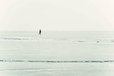 Man surfing in sea against clear sky