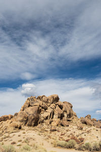 Low angle view of rock formations against sky filled with cloud layers